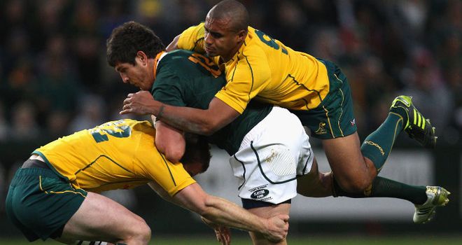 Jaque Fourie is tackled by try-scorer Pat McCabe and scrum-half Will Genia