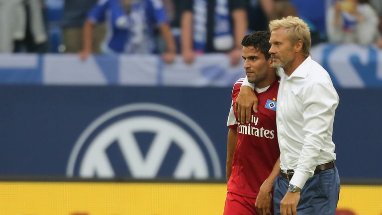 Coach Thorsten Fink of Hamburg hugs Tomas Rincon when they leave the pitch after the Bundesliga match against Schalke.
