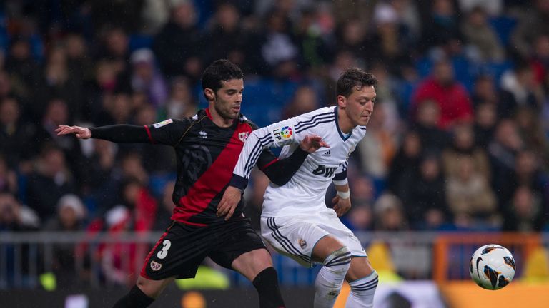 Mesut Ozil (R) of Real Madrid fends off Jose Manuel Casado of Rayo Vallecano